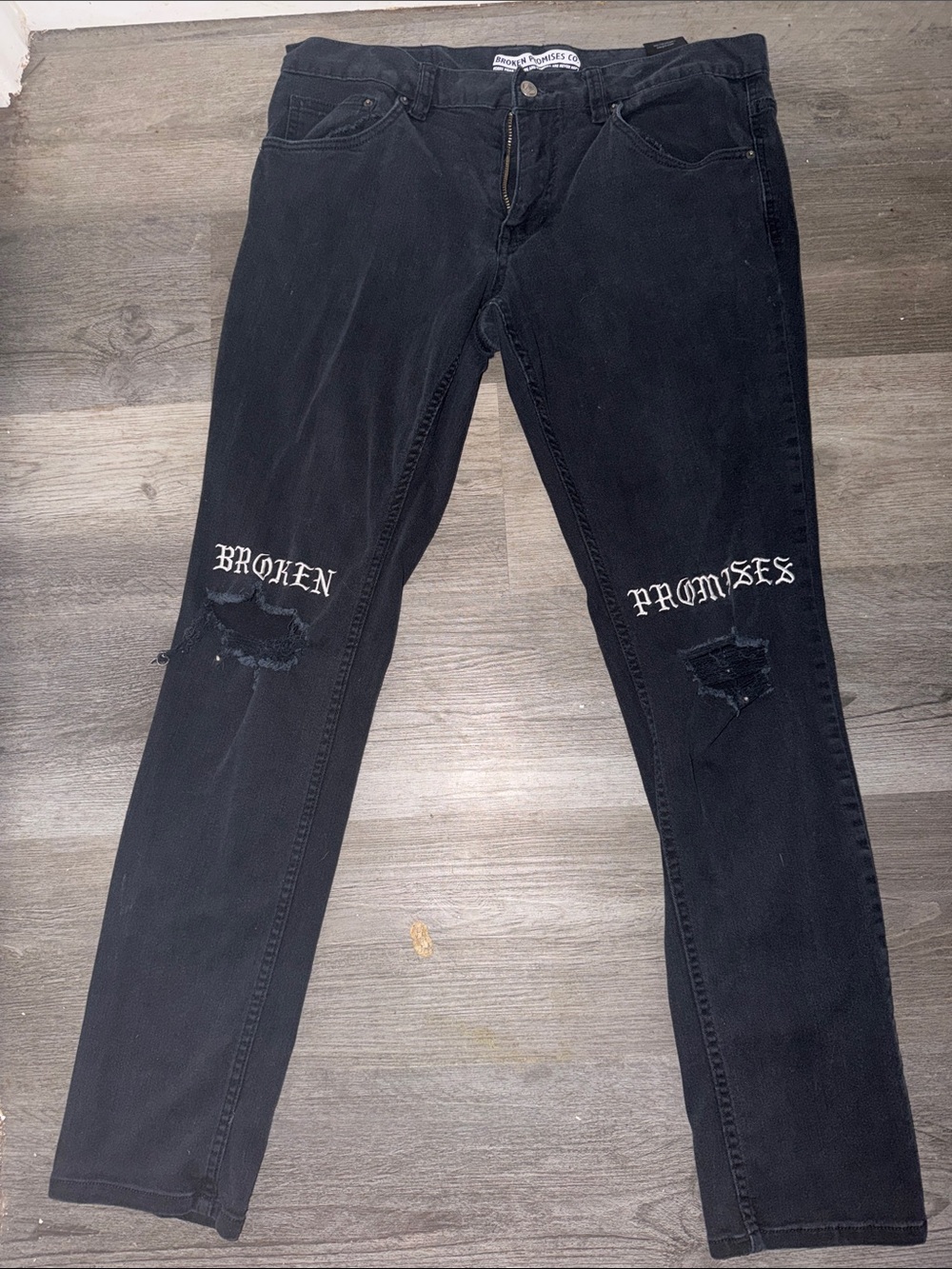 Broken Promises Men's Black Skinny Jeans with Distressed Knee Graphic